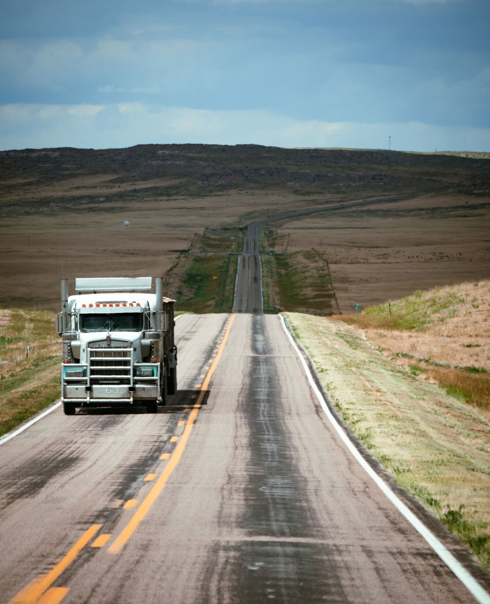 Freight truck on an open highway stretching to the horizon